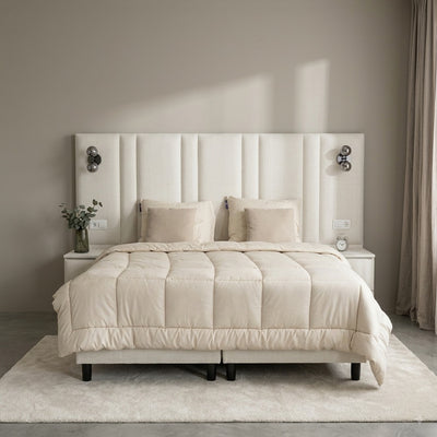 Premium boxspring op maat in creme, vooraanzicht met hoog gestoffeerd wandhoofdbord