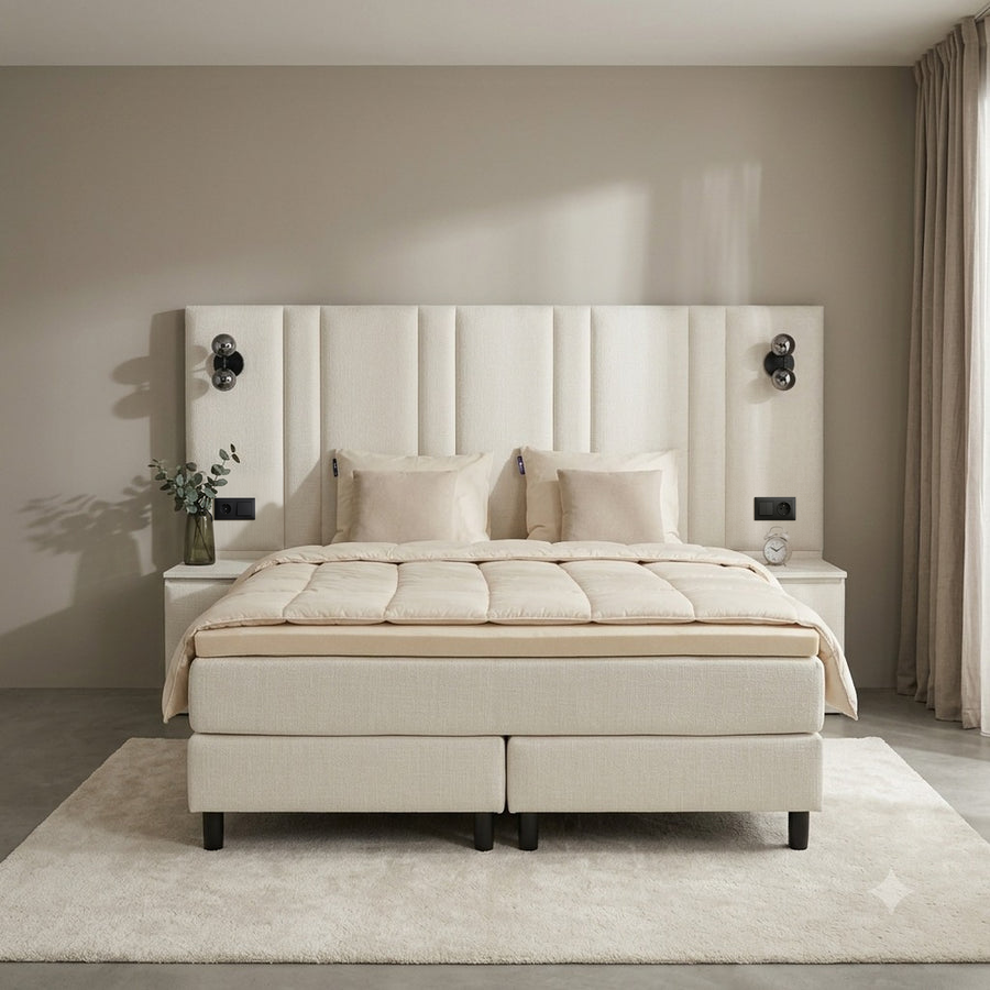 Premium boxspring met het dekbed teruggeslagen, de meegeleverde topper zichtbaar